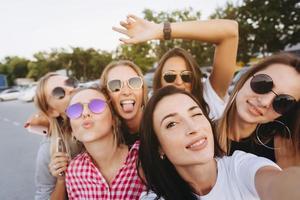 Six young beautiful girls looking at the camera and taking a selfie photo