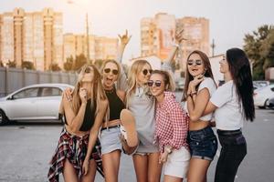 Six young women have fun at the car park. photo