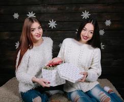 Two young girls holding holiday present photo