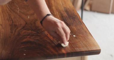 mestre carpinteiro, aplicando óleo natural na mesa de madeira natural. parte 1 video