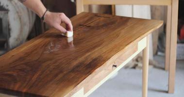 maestro carpintero, aplicando aceite natural sobre mesa de madera natural. parte 1 video