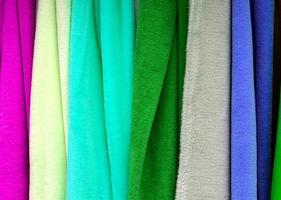 Detailed close up view on samples of cloth and fabrics in different colors found at a fabrics market photo