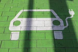 signo de una estación de carga para coches eléctricos pintados en un estacionamiento azul foto