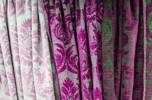 Detailed close up view on samples of cloth and fabrics in different colors found at a fabrics market photo