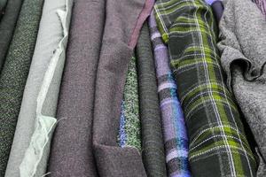 Detailed close up view on samples of cloth and fabrics in different colors found at a fabrics market photo