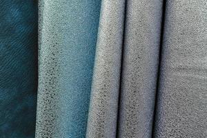 Detailed close up view on samples of cloth and fabrics in different colors found at a fabrics market photo
