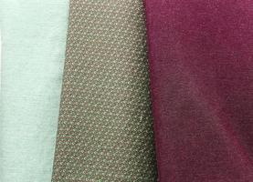 Detailed close up view on samples of cloth and fabrics in different colors found at a fabrics market photo