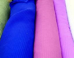 Detailed close up view on samples of cloth and fabrics in different colors found at a fabrics market photo