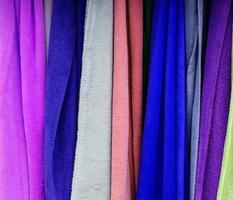 Detailed close up view on samples of cloth and fabrics in different colors found at a fabrics market photo