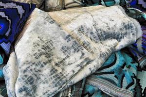 Detailed close up view on samples of cloth and fabrics in different colors found at a fabrics market photo