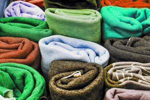 Detailed close up view on samples of cloth and fabrics in different colors found at a fabrics market photo