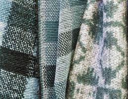Detailed close up view on samples of cloth and fabrics in different colors found at a fabrics market photo