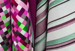 Detailed close up view on samples of cloth and fabrics in different colors found at a fabrics market photo