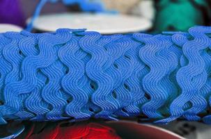 Detailed close up view on samples of cloth and fabrics in different colors found at a fabrics market photo