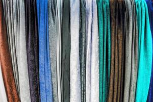Detailed close up view on samples of cloth and fabrics in different colors found at a fabrics market photo