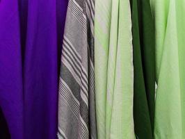 Detailed close up view on samples of cloth and fabrics in different colors found at a fabrics market photo