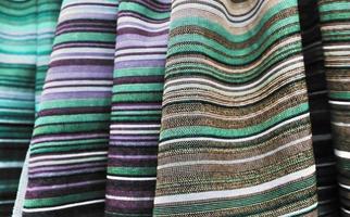 Detailed close up view on samples of cloth and fabrics in different colors found at a fabrics market photo
