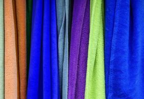 Detailed close up view on samples of cloth and fabrics in different colors found at a fabrics market photo