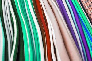 Detailed close up view on samples of cloth and fabrics in different colors found at a fabrics market photo