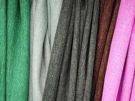 Detailed close up view on samples of cloth and fabrics in different colors found at a fabrics market photo
