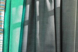 Detailed close up view on samples of cloth and fabrics in different colors found at a fabrics market photo