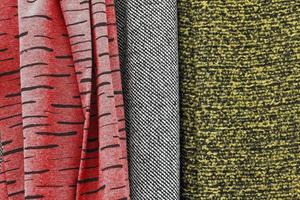 Detailed close up view on samples of cloth and fabrics in different colors found at a fabrics market photo