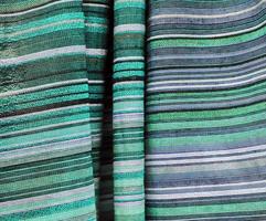 Detailed close up view on samples of cloth and fabrics in different colors found at a fabrics market photo