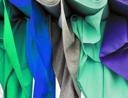 Detailed close up view on samples of cloth and fabrics in different colors found at a fabrics market photo