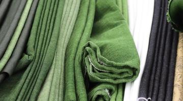 Detailed close up view on samples of cloth and fabrics in different colors found at a fabrics market photo