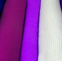 Detailed close up view on samples of cloth and fabrics in different colors found at a fabrics market photo