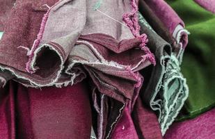 Detailed close up view on samples of cloth and fabrics in different colors found at a fabrics market photo