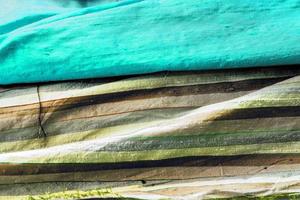 Detailed close up view on samples of cloth and fabrics in different colors found at a fabrics market photo