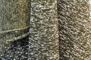 Detailed close up view on samples of cloth and fabrics in different colors found at a fabrics market photo