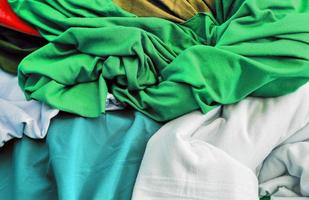 Detailed close up view on samples of cloth and fabrics in different colors found at a fabrics market photo