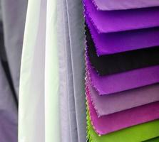 Detailed close up view on samples of cloth and fabrics in different colors found at a fabrics market photo