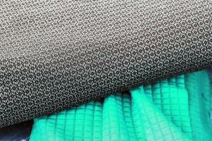 Detailed close up view on samples of cloth and fabrics in different colors found at a fabrics market photo