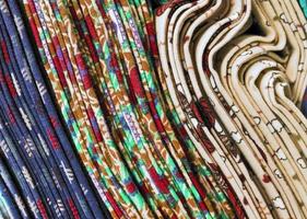 Detailed close up view on samples of cloth and fabrics in different colors found at a fabrics market photo