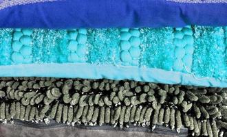 Detailed close up view on samples of cloth and fabrics in different colors found at a fabrics market photo