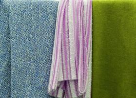Detailed close up view on samples of cloth and fabrics in different colors found at a fabrics market photo