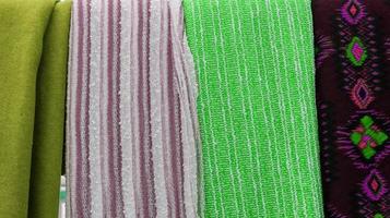 Detailed close up view on samples of cloth and fabrics in different colors found at a fabrics market photo