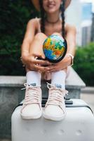 Cropped photo. Beautiful young woman holds a small globe photo