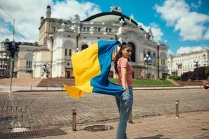 mujer joven con bandera nacional de ucrania en la calle foto