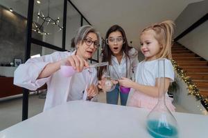 Family doing chemical experiment, mixing flasks indoors photo