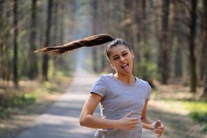 bella joven corriendo en un parque verde en un día soleado de verano foto