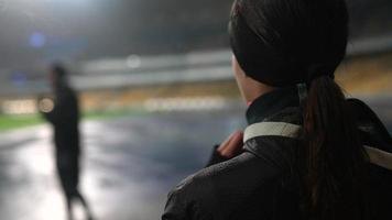 People go in for sports at night stadium in rainy weather photo