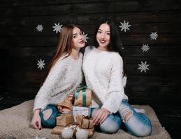 Two pretty girls with gifts for Christmas photo