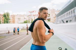 Young muscular guy with a naked torso looking back over his shoulder. photo