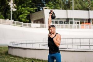 Sportive guy training with kettlebell. Strength and motivation. photo