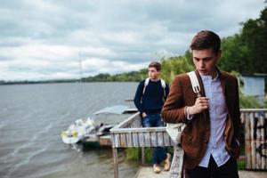 two young guys standing on a pier photo