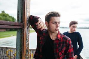 two guys stand in an abandoned building on lake photo